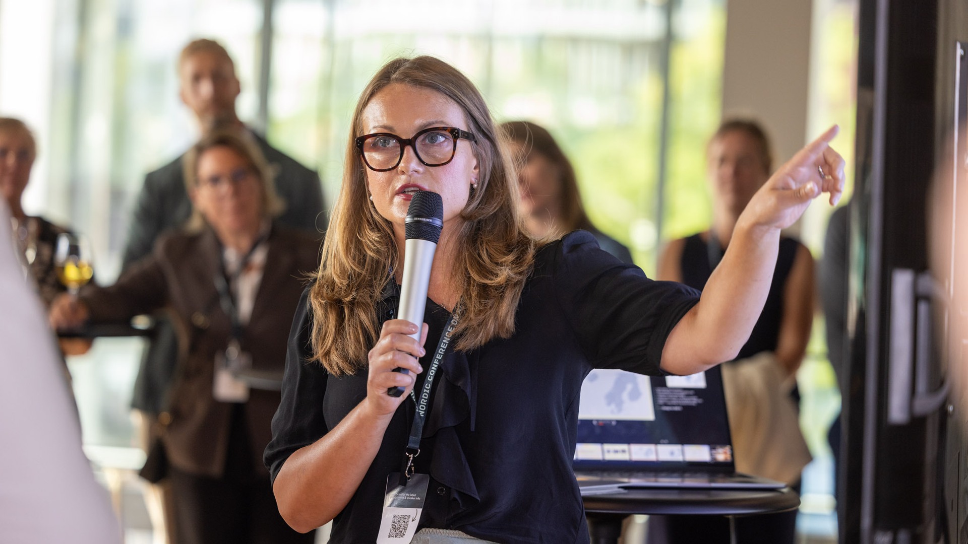 Lorna Bartram speaking into a microphone in front of a group of people.
