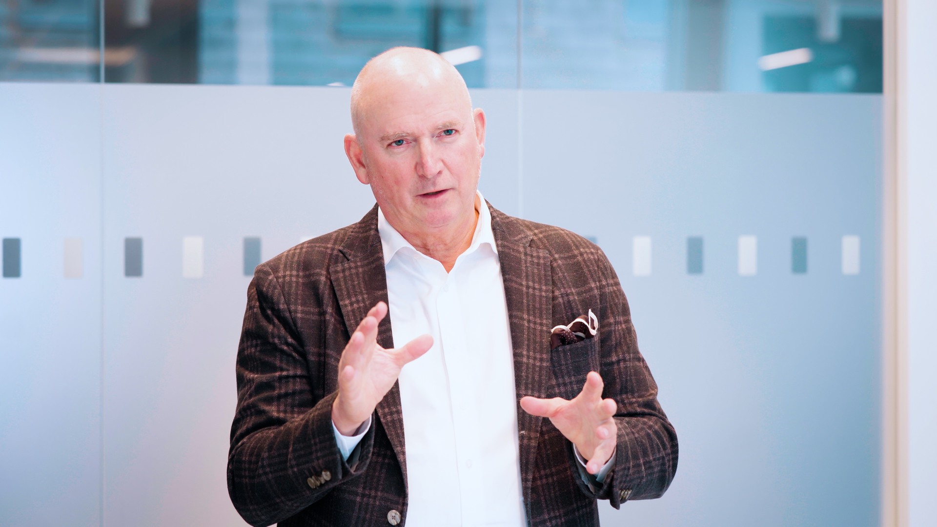 Christophe Pedroletti, CEO of Karolinska University Hospital, standing in front of a glass wall.
