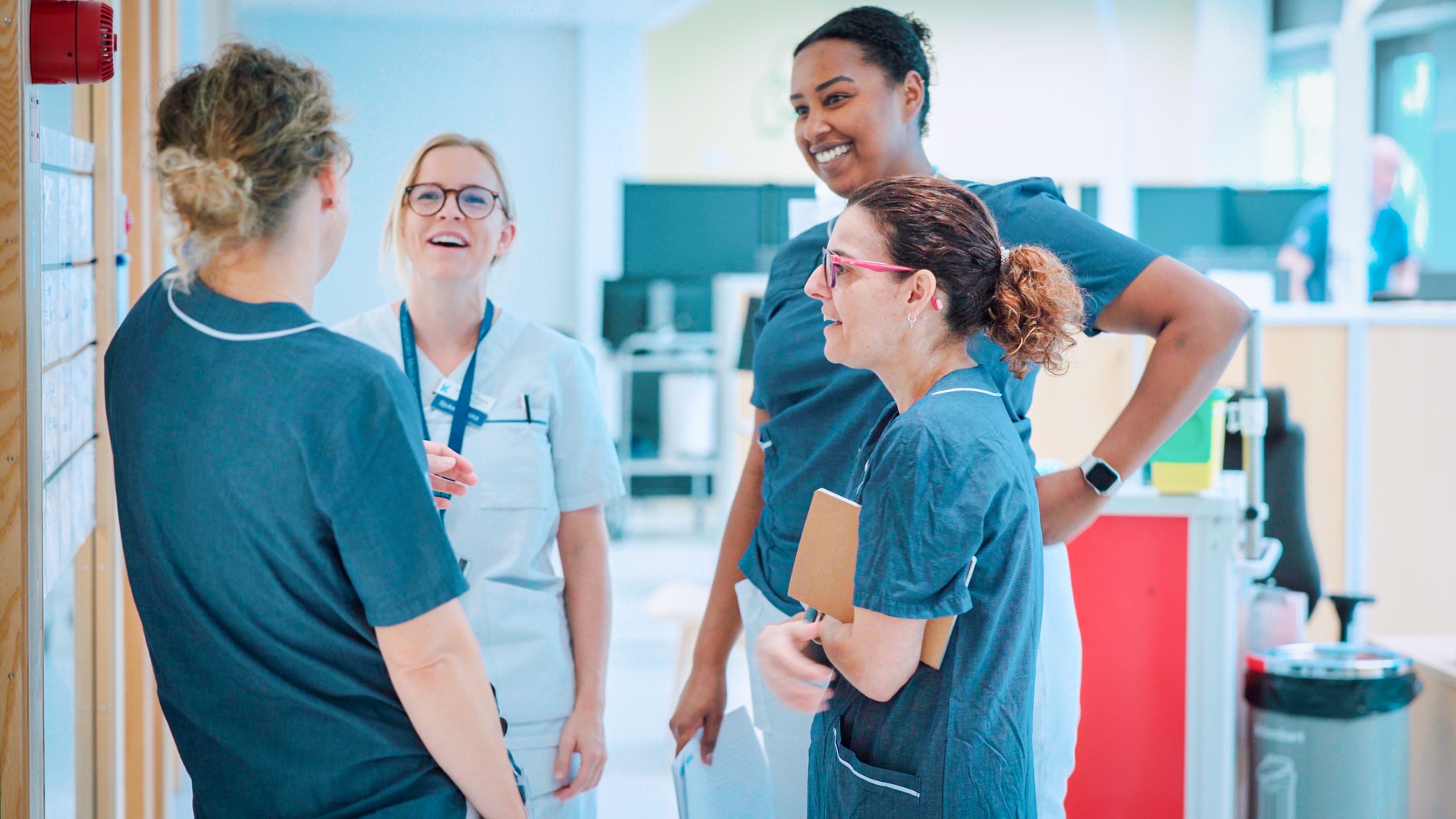 A group of people standing around each other in a room.