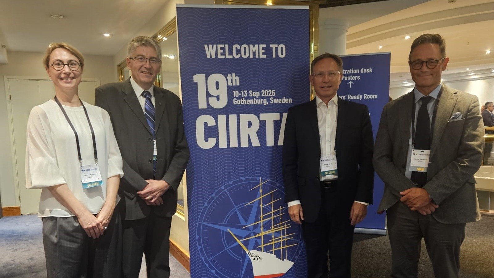 A group of people standing in front of a sign.