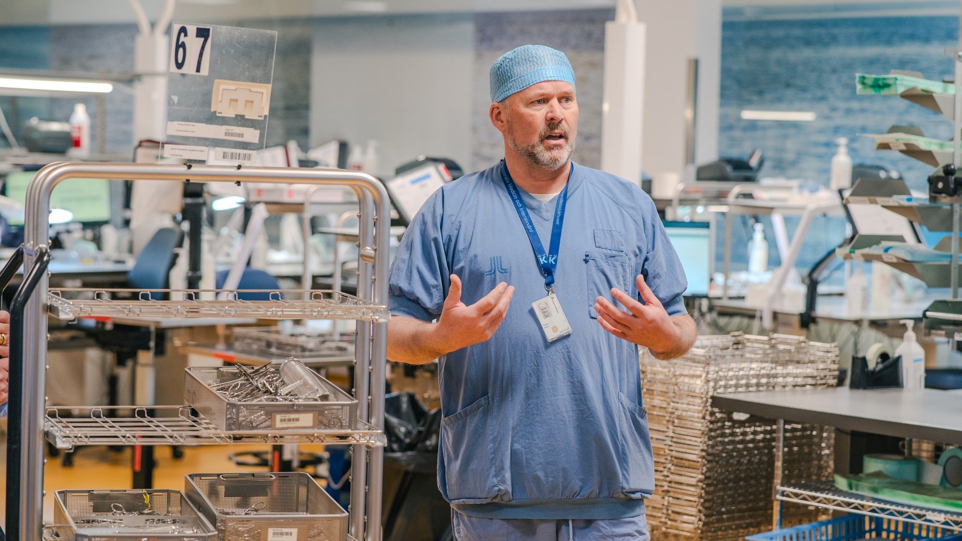 A man in scrubs stands in front of a machine.