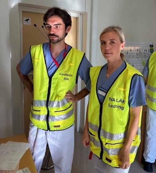 En man och en kvinna i gula västar står bredvid varandra.