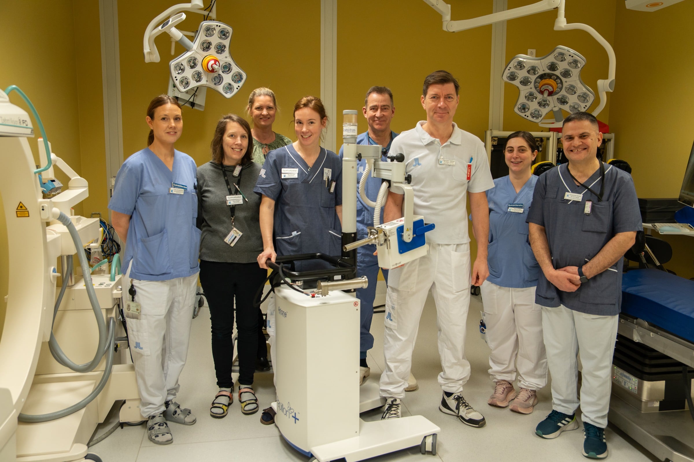 A group of doctors standing in a hospital room.