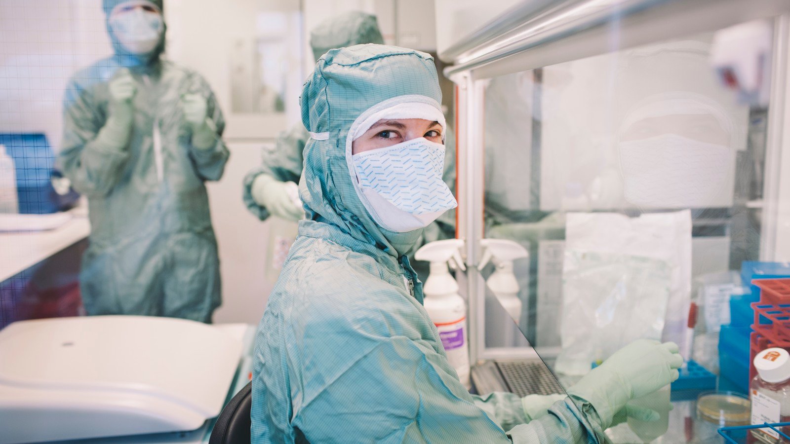 A person in a medical gown and mask in a room.