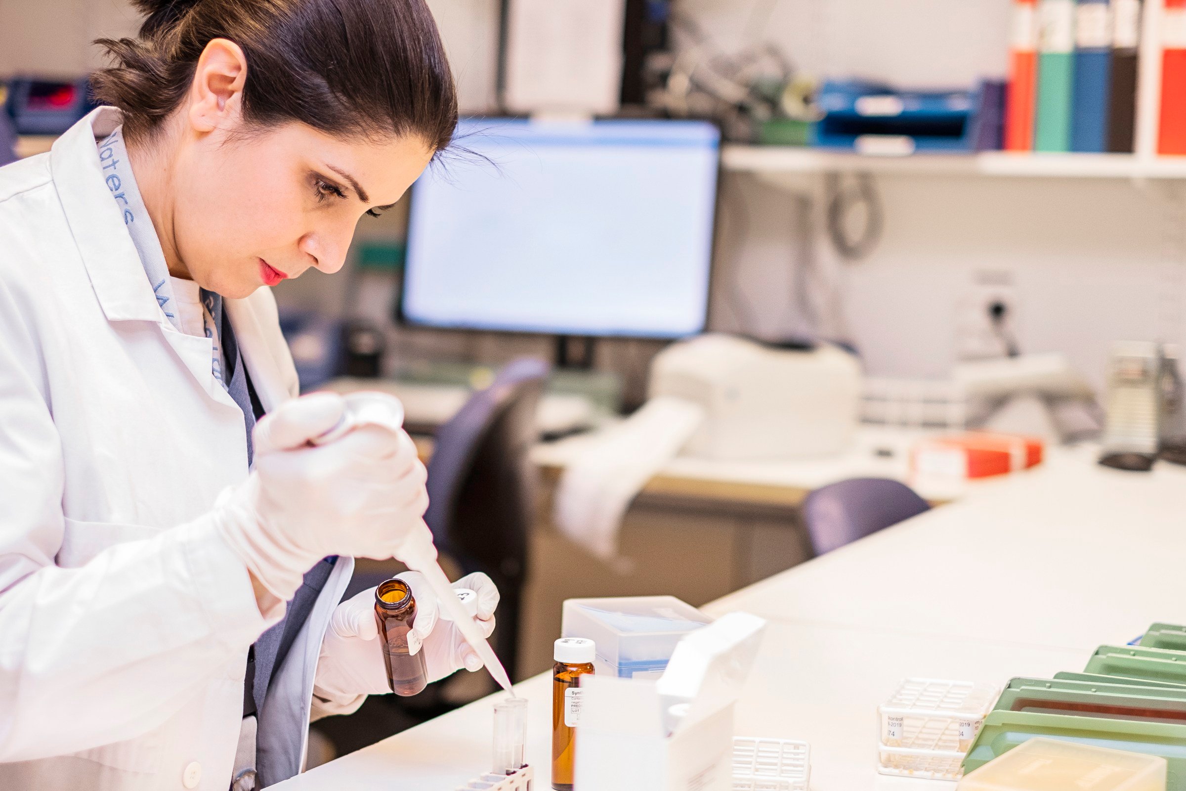 a person dressed in medical clothing is using a pipette