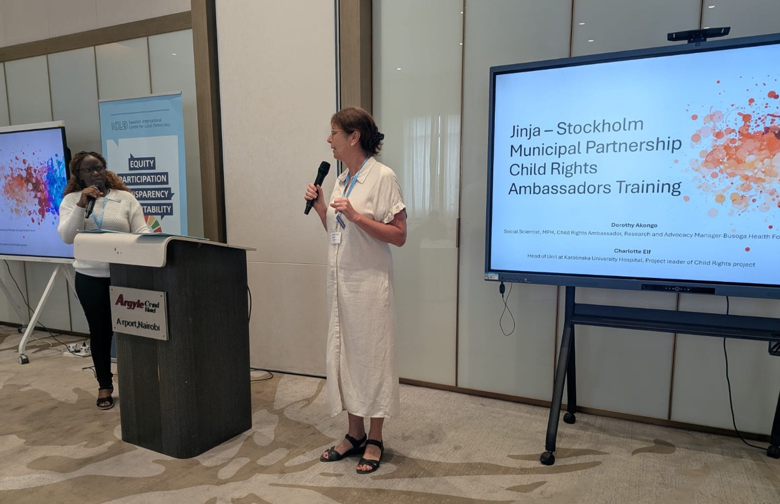 A woman standing at a podium with a microphone.