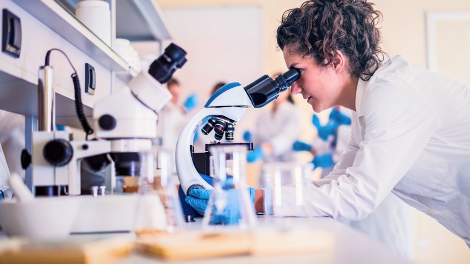 Researcher looking into microscope.